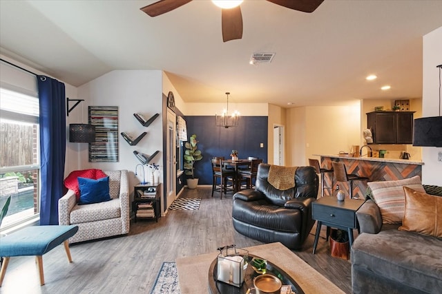 living room featuring vaulted ceiling, dark hardwood / wood-style floors, and ceiling fan with notable chandelier