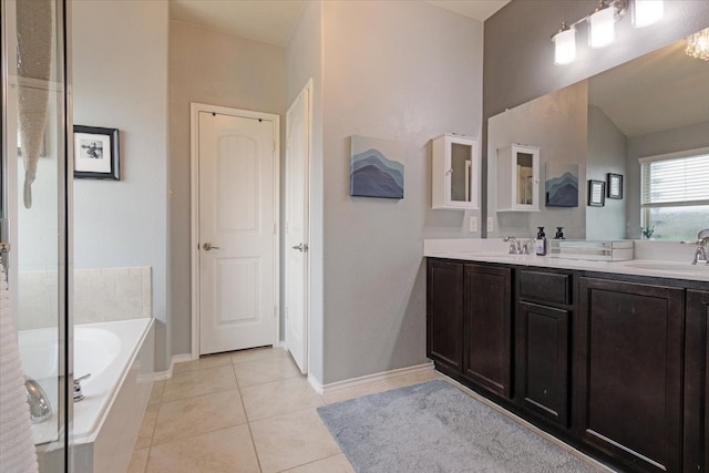 bathroom featuring vanity, tiled bath, and tile patterned flooring