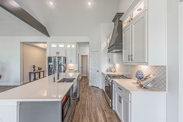 kitchen with an island with sink, stainless steel appliances, backsplash, and custom exhaust hood