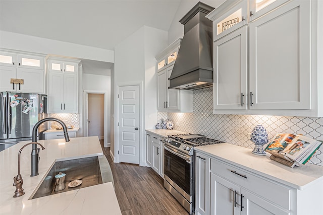 kitchen with white cabinetry, dark wood-type flooring, stainless steel appliances, premium range hood, and backsplash