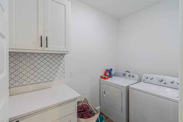 washroom with washer and dryer and cabinets