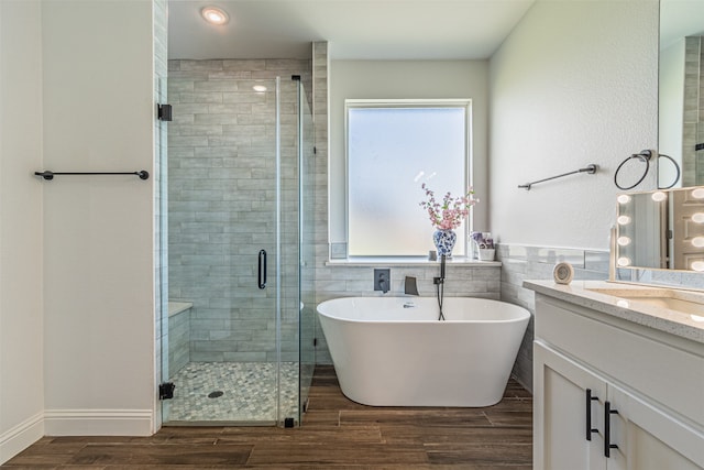 bathroom with a wealth of natural light, independent shower and bath, and vanity with extensive cabinet space