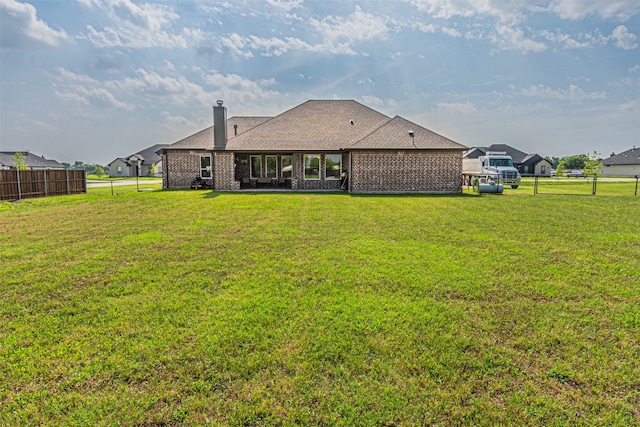 rear view of house with a yard