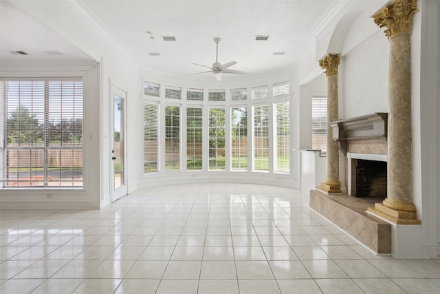 unfurnished living room featuring a high end fireplace, ceiling fan, ornamental molding, and light tile floors