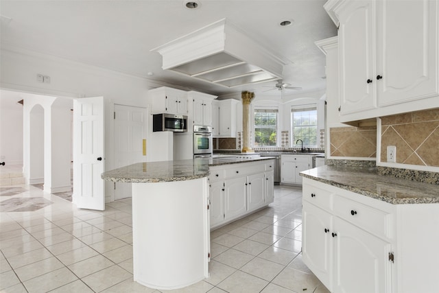 kitchen featuring a center island, white cabinets, backsplash, and appliances with stainless steel finishes