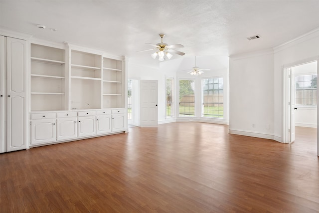 unfurnished living room with built in features, ceiling fan, ornamental molding, wood-type flooring, and a textured ceiling