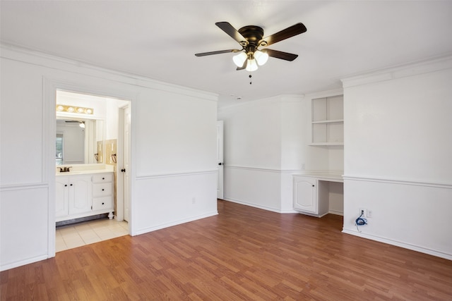 unfurnished living room with sink, hardwood / wood-style flooring, ornamental molding, and ceiling fan