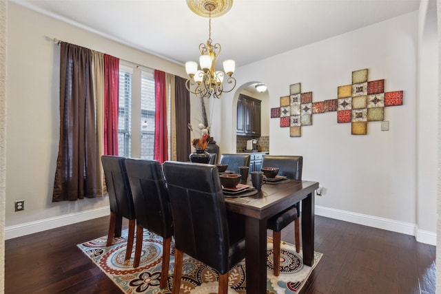 dining space featuring dark hardwood / wood-style floors and a notable chandelier