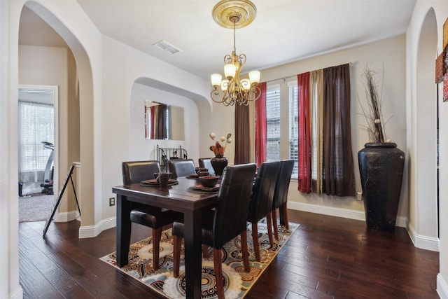 dining area featuring dark hardwood / wood-style floors, plenty of natural light, and a chandelier