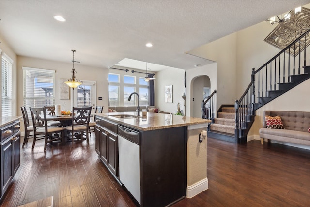 kitchen featuring ceiling fan, sink, a kitchen island with sink, and dark wood-type flooring