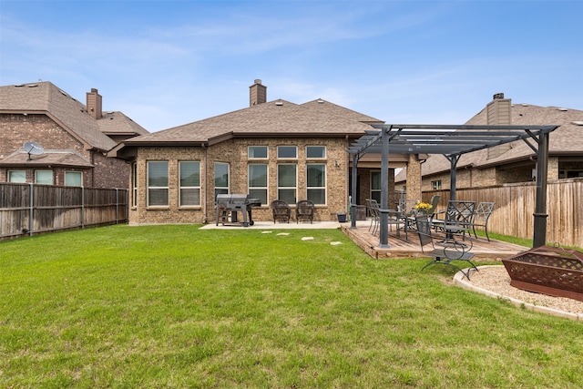 rear view of property featuring a patio, a pergola, and a yard