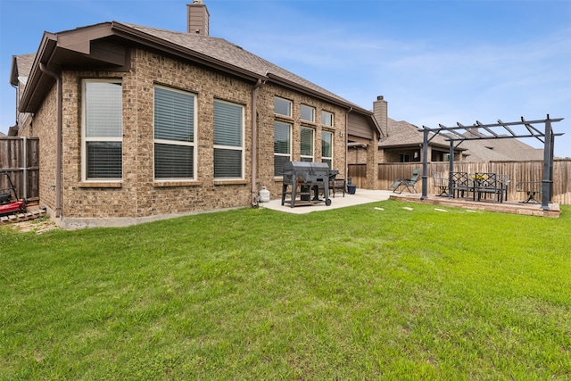 rear view of property featuring a yard, a pergola, and a patio area