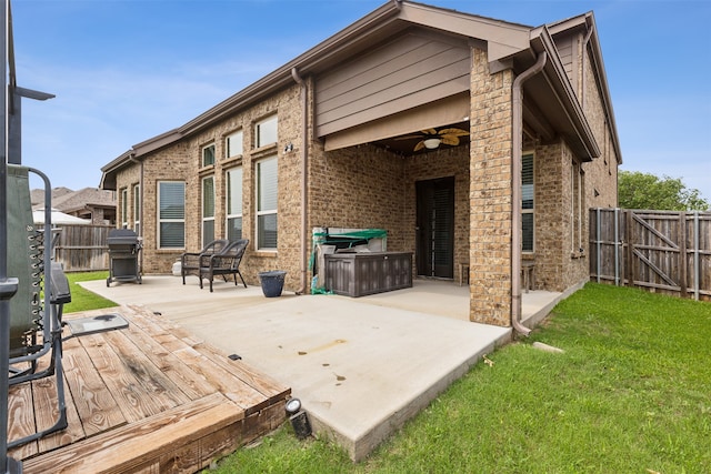 wooden deck featuring a yard, ceiling fan, a grill, and a patio area