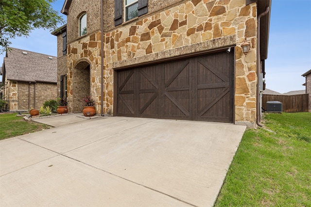 garage with a yard and central air condition unit