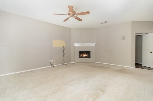 unfurnished living room featuring carpet and ceiling fan