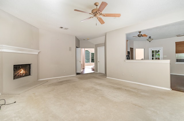 unfurnished living room with a healthy amount of sunlight, carpet, and ceiling fan