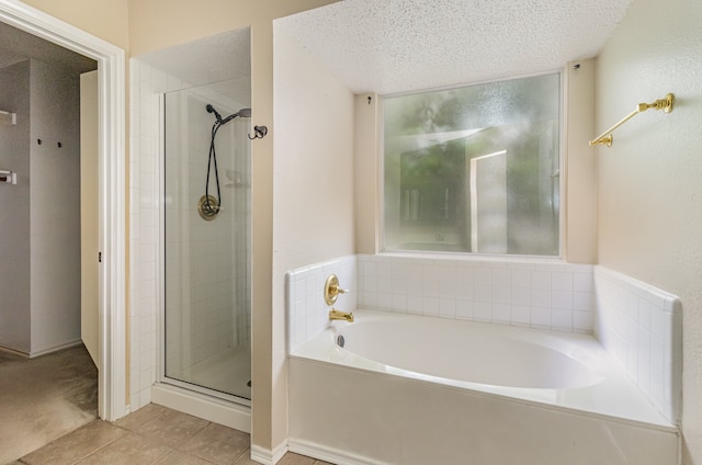 bathroom with tile flooring, a textured ceiling, and plus walk in shower