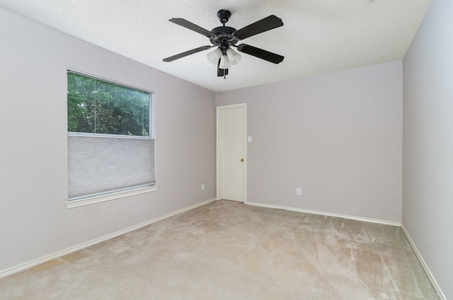 carpeted empty room with a textured ceiling and ceiling fan