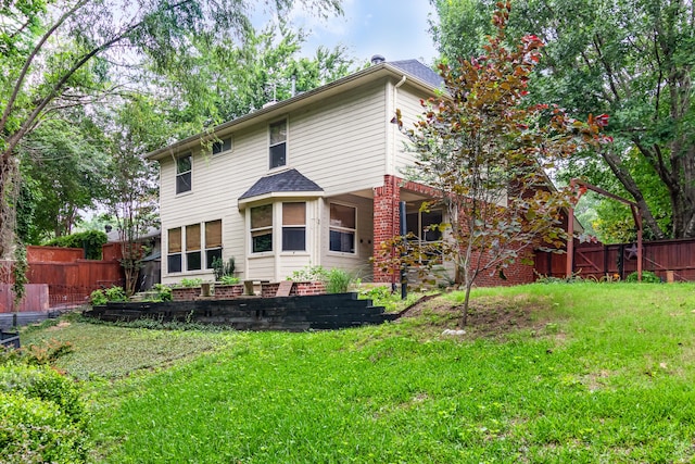 back of house with a lawn