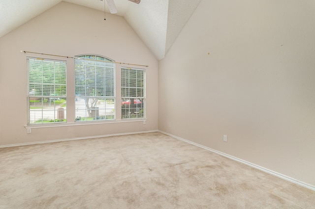 carpeted spare room featuring high vaulted ceiling and ceiling fan