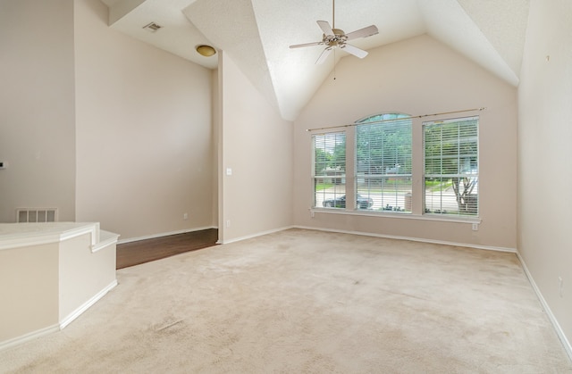 carpeted empty room with high vaulted ceiling, ceiling fan, and a textured ceiling