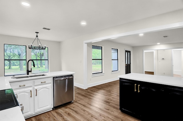 kitchen featuring dishwasher, hanging light fixtures, white cabinets, and light hardwood / wood-style floors