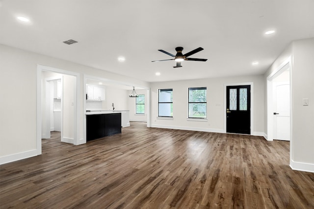 unfurnished living room with sink, dark hardwood / wood-style floors, and ceiling fan