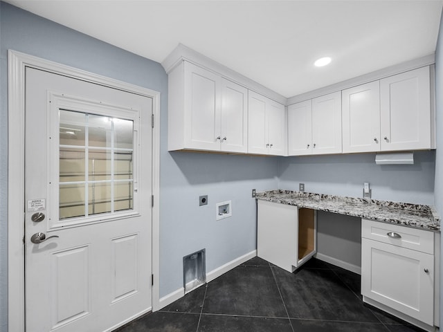 clothes washing area with hookup for an electric dryer, hookup for a washing machine, dark tile patterned floors, and cabinets