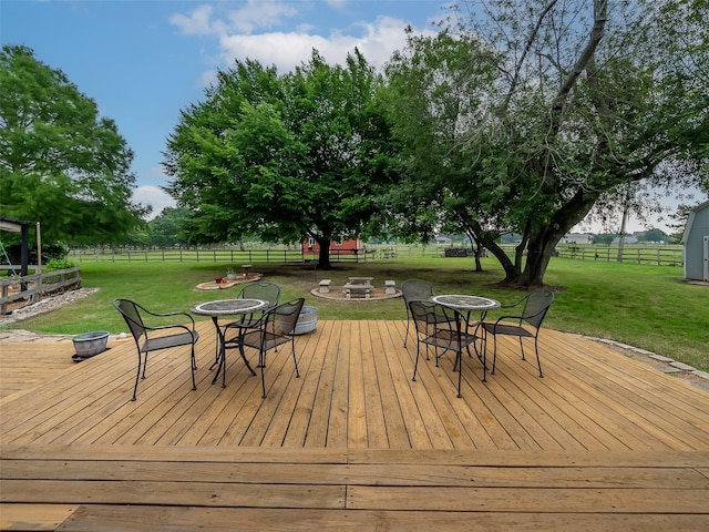 deck featuring an outdoor fire pit and a lawn