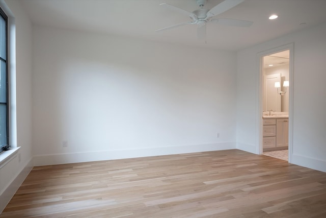 unfurnished bedroom featuring light hardwood / wood-style flooring, ceiling fan, ensuite bathroom, and sink