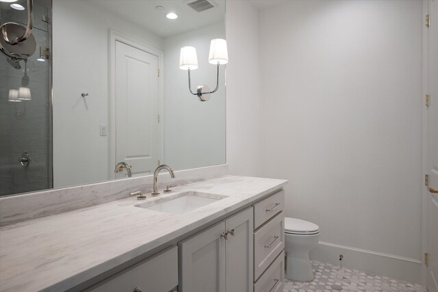 bathroom with tile patterned floors, a shower with door, vanity, and toilet