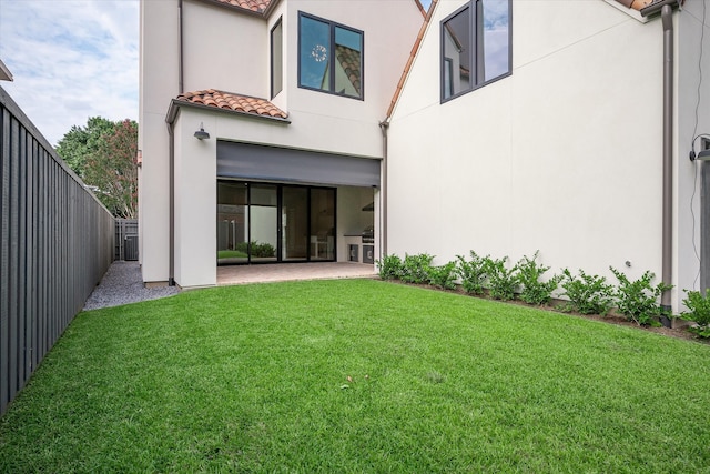 rear view of property featuring a patio and a lawn