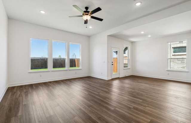 unfurnished living room featuring ceiling fan and dark hardwood / wood-style flooring