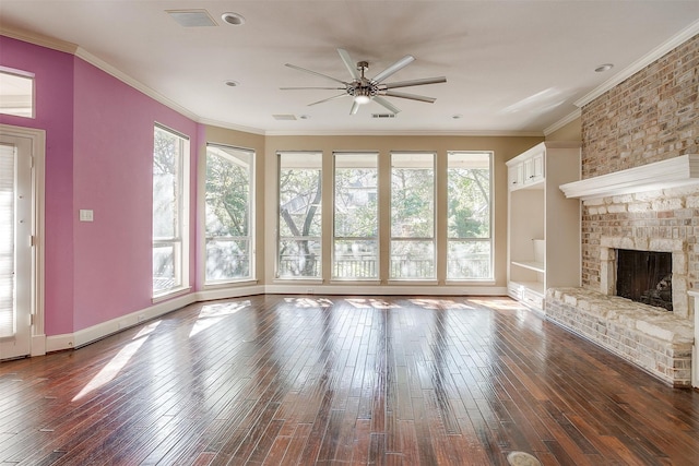 unfurnished living room with ornamental molding, a fireplace, dark wood-type flooring, and a healthy amount of sunlight