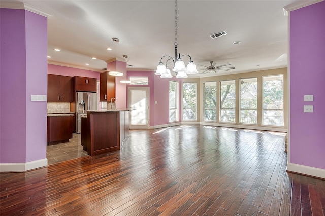 unfurnished living room with crown molding, dark hardwood / wood-style floors, and ceiling fan with notable chandelier