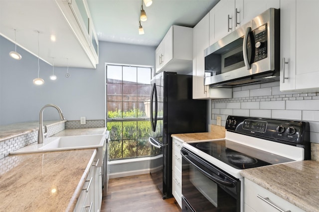 kitchen with light stone countertops, tasteful backsplash, black electric range oven, white cabinets, and light wood-type flooring