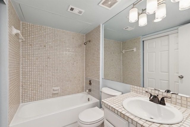 full bathroom with backsplash, vanity, tiled shower / bath, and toilet