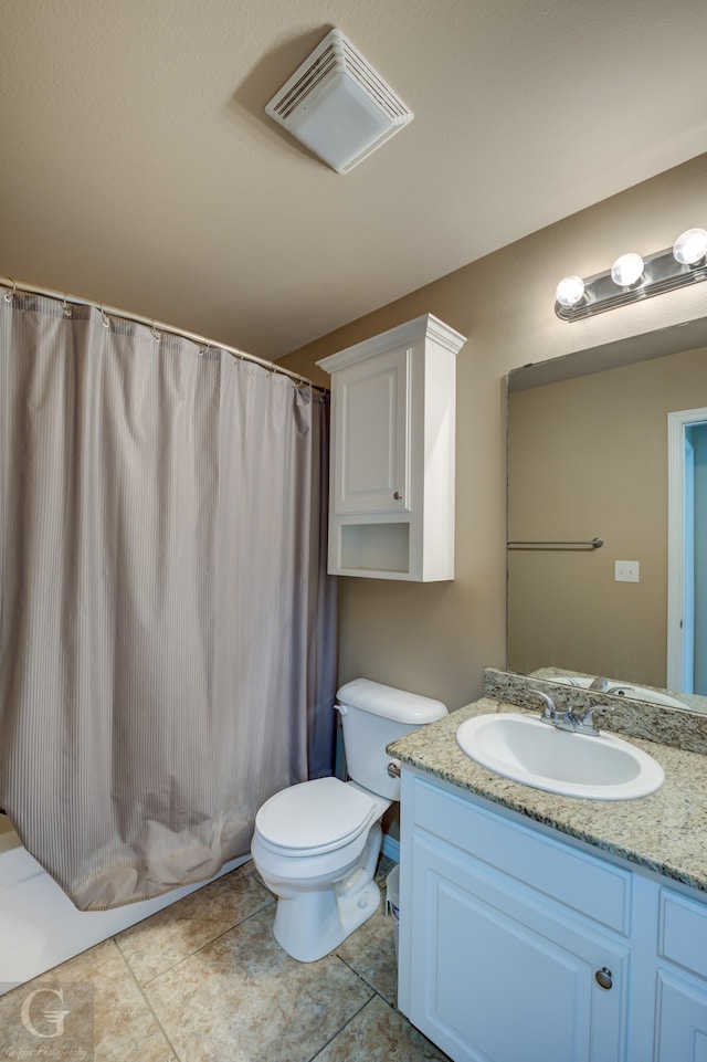 bathroom with tile flooring, oversized vanity, and toilet