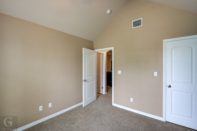 unfurnished bedroom featuring high vaulted ceiling and carpet floors