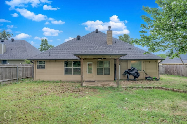 rear view of property with a patio and a lawn