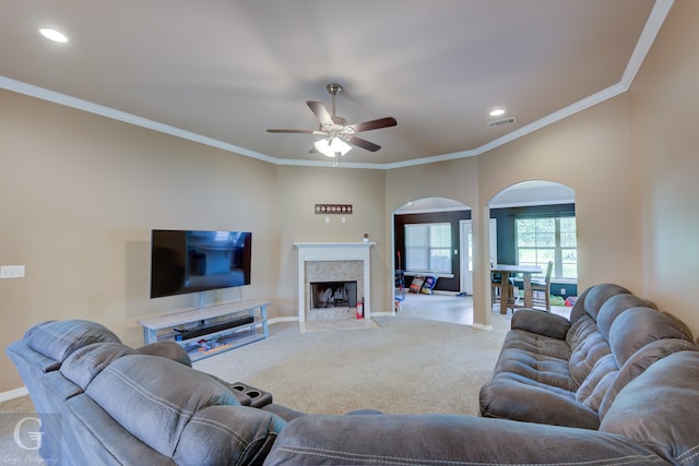 living room with crown molding, carpet, ceiling fan, and a premium fireplace