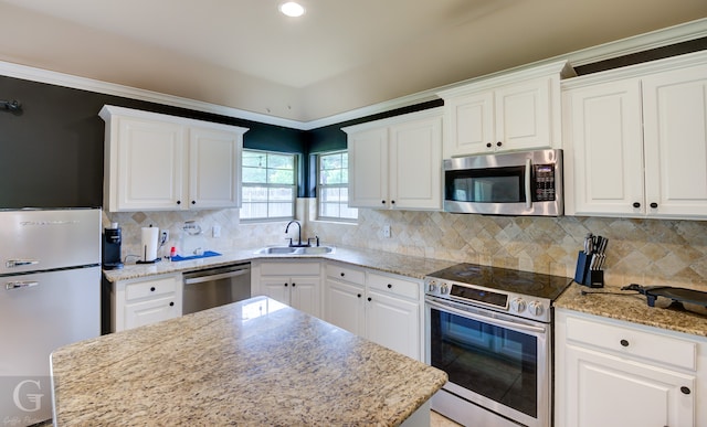 kitchen with backsplash, appliances with stainless steel finishes, and white cabinetry