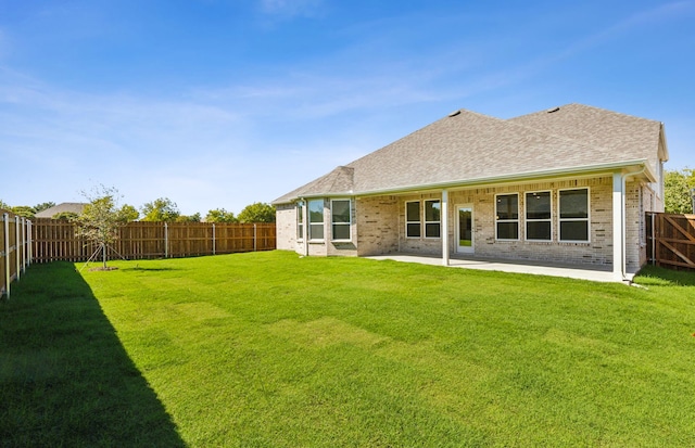 rear view of property with a patio area and a yard