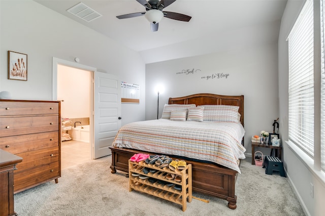 carpeted bedroom featuring ceiling fan, ensuite bath, and lofted ceiling