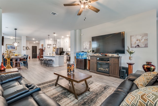 living room with ceiling fan and light hardwood / wood-style floors