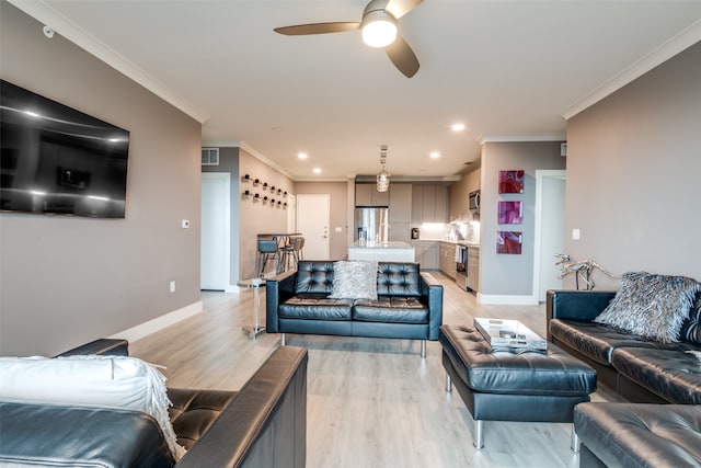 living room with ceiling fan, light wood-type flooring, and ornamental molding