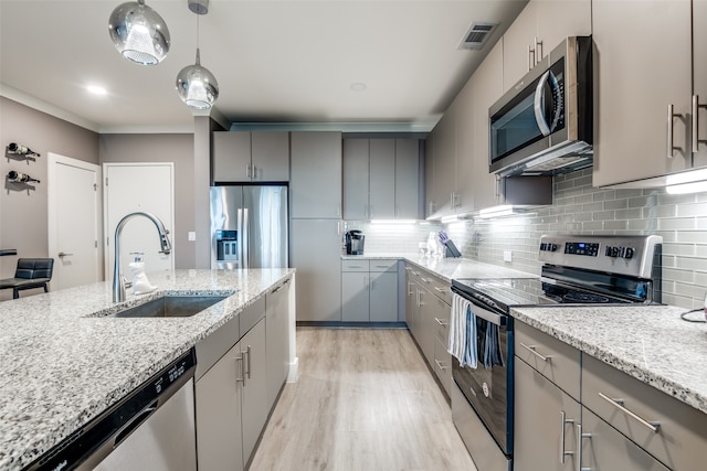 kitchen featuring light hardwood / wood-style floors, stainless steel appliances, light stone counters, backsplash, and sink