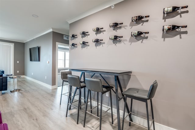 dining area featuring ornamental molding and light wood-type flooring