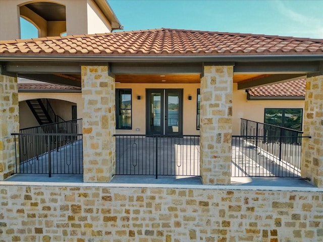 entrance to property with a tiled roof and stone siding