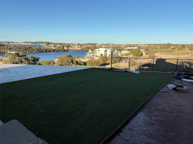 view of yard featuring fence and a water view